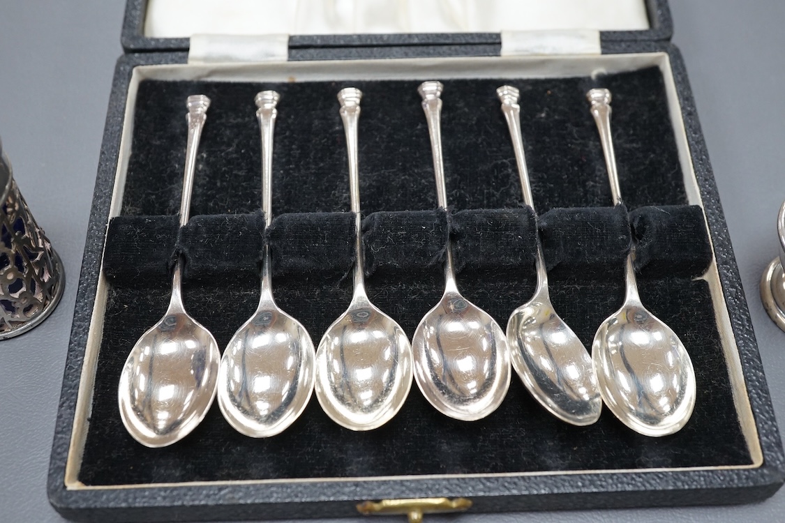 Four assorted silver napkin rings, two cased sets of six silver spoons, four silver condiments including a pair, a small group of sundry flatware, a silver wine label and a plated napkin ring.